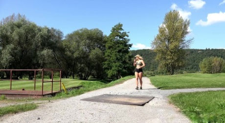 Blonde girl Chrissy squats for a pee on a path while crossing a golf course 64212941