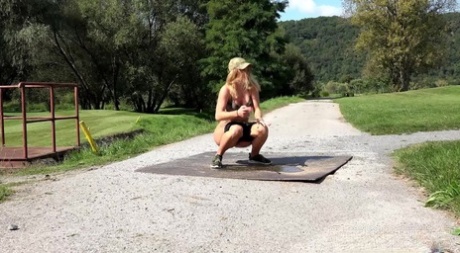 Blonde girl Chrissy squats for a pee on a path while crossing a golf course 64212941