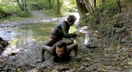 Lesbian lovers cover each other in mud while completely dressed 90949809