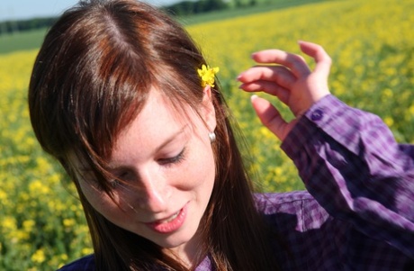 Redheaded teen pauses for a moment before getting naked in a field of crops 73917056