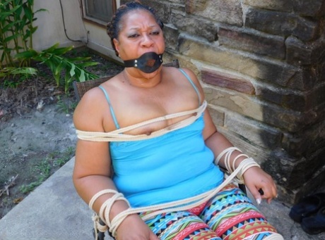 Black woman is left tied to a patio chair while gagged as well 30323862