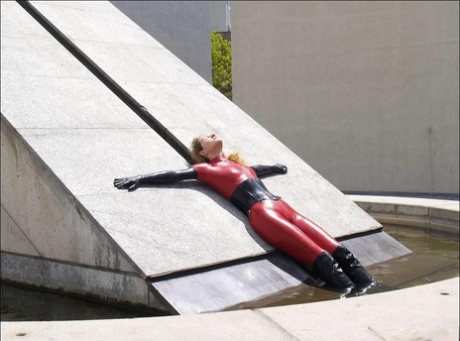 Solo girl models red latex clothing outdoors in black gloves and boots 39085977