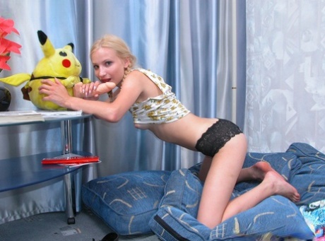 Skinny blonde teen slips a dildo inside her hairless vagina on some cushions 26071908