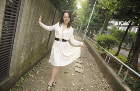 Classy Japanese female Yuna Yamami models non nude outdoors in a white dress 22602354