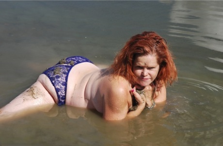 Redheaded amateur Misha covers her big tits in mud while in shallow water 58572850