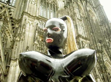 Fetish model poses outside of a cathedral in head to toe latex clothing 63567094