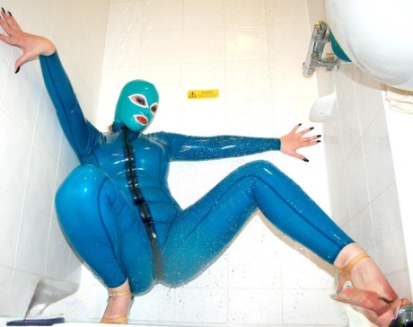 Solo model poses in latex clothing and a mask while wearing high heels 57739061
