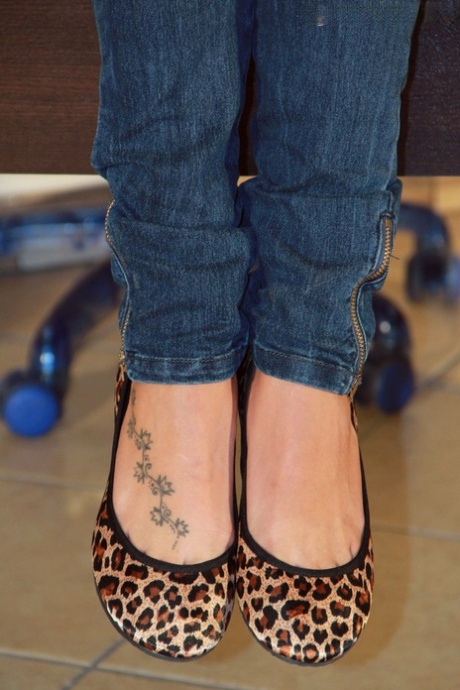 Solo girl in denim jeans and a jacket releases bare feet from flat shoes 17624248