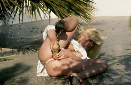 Blonde chick with a 70's haircut plays with her hairy snatch in garden patio 86060624