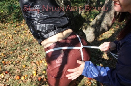 Lesbian girls partake in bondage play in a yard while fully clothed 38685919