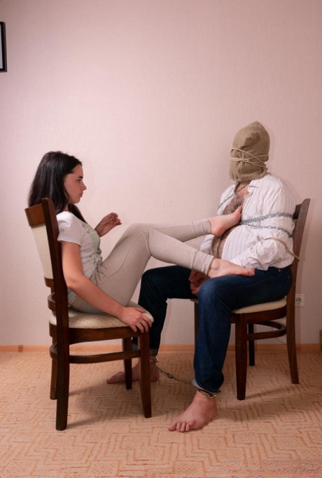 Burnett woman has her bare feet attended to by a restrained male slave 25630050