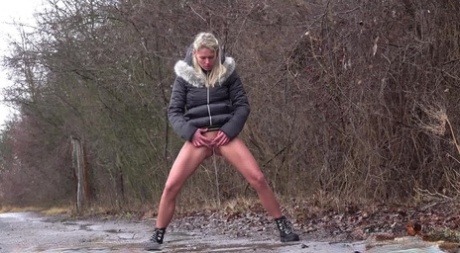Platinum blonde Claudia Macc takes a piss on a paved road in the countryside 81377842