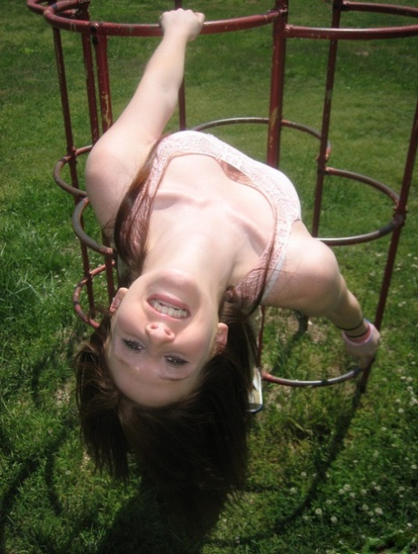 Natural redhead flashes her tits on playground equipment in a field 64616842