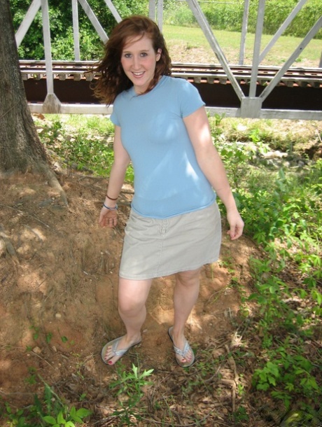 Pale redhead uncovers her small boobs near model railroad tracks 71117932