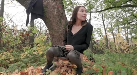 Brunette chick Sasha pulls down her leather pants to take a piss by a tree 39474887