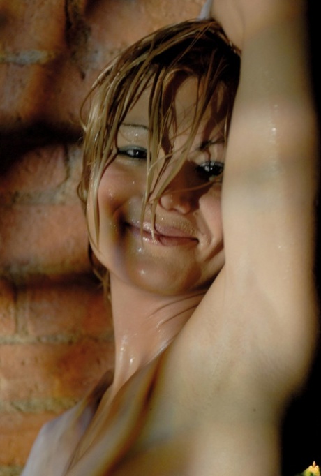 Glamour model sports the wet look while naked against a brick wall 51213886