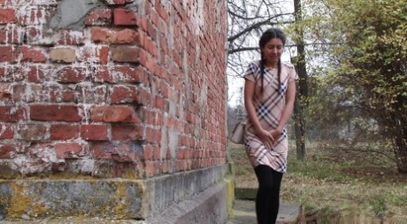 Nice girl pulls down black tights for quick pee behind a building 86496315