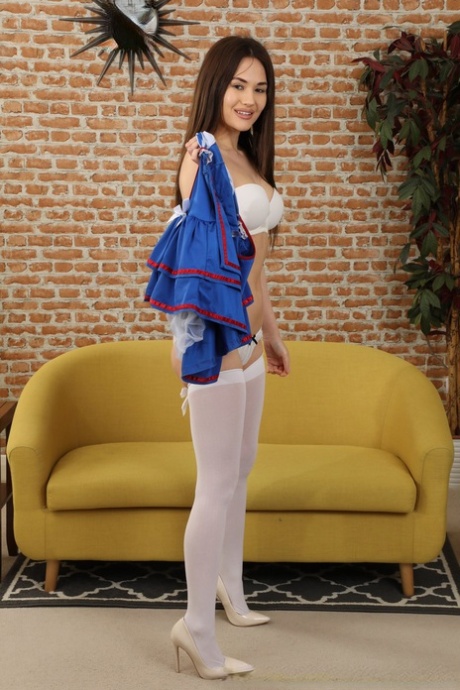 Sweet brunette Daisy Rose doffs a sailor girl dress to model a bra and nylons 41904907