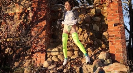 Solo girl Kaeyes pisses over some rubble during the day in neon stockings 32225262