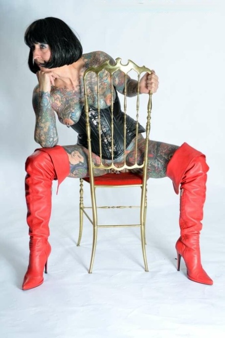 Solo girl Tattoogirl Cleo gets naked in a leather waist cincher and long boots