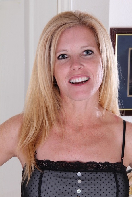 Mature blonde with a nice smile slips off black heels to model totally naked 53417204